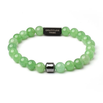 Green beaded bracelet with a black tag labeled 'Gratitude Tribe' on a white background, green, black, front.