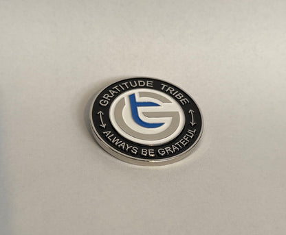 Circular metal badge with 'Gratitude Tribe' logo and text on a light gray background, coin, front,